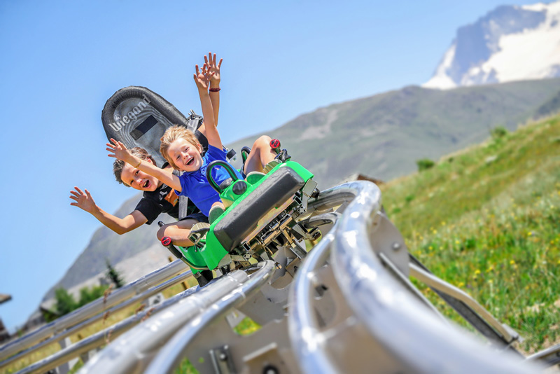 2 enfants sur une luge sur rail en extérieur